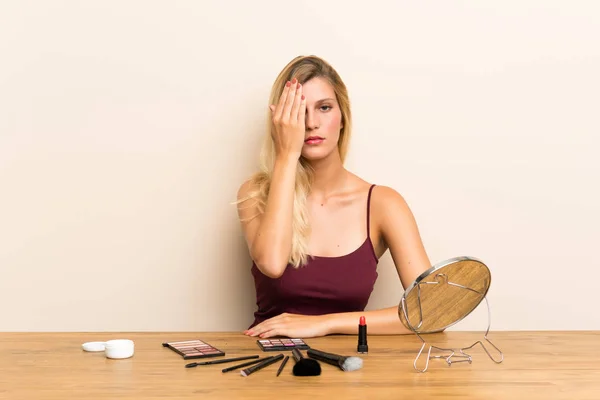 Jeune Femme Blonde Avec Cosmétique Dans Une Table Couvrant Oeil — Photo