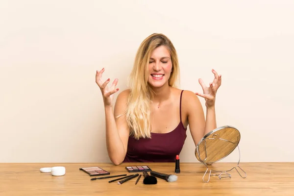 Jeune Femme Blonde Avec Cosmétique Dans Une Table Malheureuse Frustrée — Photo