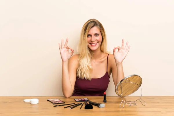 Junge Blonde Frau Mit Kosmetik Einem Tisch Zeigt Ein Zeichen — Stockfoto