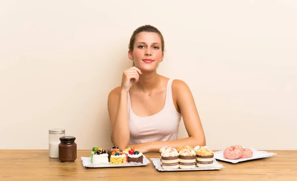 Junge Frau Mit Vielen Verschiedenen Mini Kuchen Einem Tisch Lachend — Stockfoto