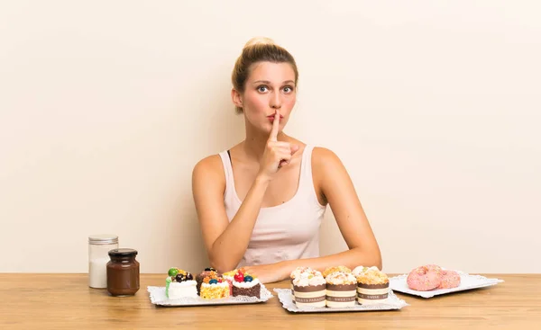 Junge Frau Mit Vielen Verschiedenen Mini Kuchen Auf Einem Tisch — Stockfoto
