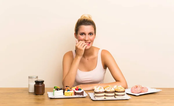 Junge Frau Mit Vielen Verschiedenen Mini Kuchen Einem Tisch Nervös — Stockfoto