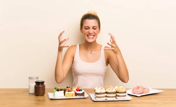 Junge Frau Mit Vielen Verschiedenen Mini Kuchen Einem Tisch Unglücklich — Stockfoto