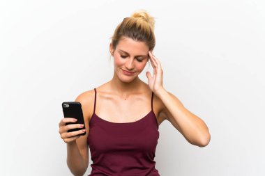 Genç sarışın kadın cep telefonu kullanarak mutsuz ve bir şey ile sinirli. Negatif yüz ifadesi