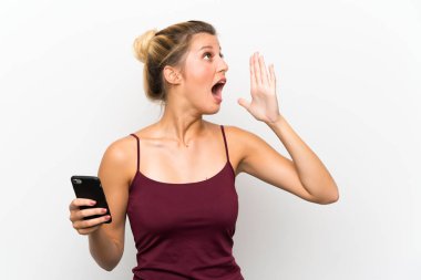 Ağzı tamamen açık bağırarak cep telefonu kullanarak genç sarışın kadın