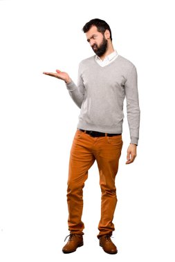 İzole beyaz arka plan üzerinde şüpheleri ile copyspace tutan yakışıklı adam