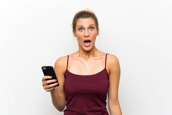 驚きの表情で携帯電話を使用して若いブロンドの女性 — ストック写真