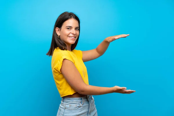 Chica Joven Sobre Fondo Azul Aislado Sosteniendo Copyspace Para Insertar — Foto de Stock