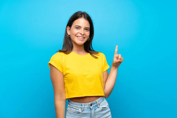 Menina Sobre Fundo Azul Isolado Mostrando Levantando Dedo Sinal Melhor — Fotografia de Stock