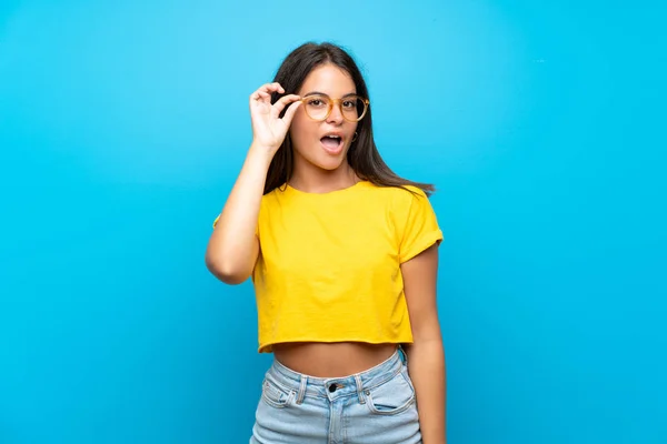 Jovem Sobre Fundo Azul Isolado Com Óculos Surpreso — Fotografia de Stock