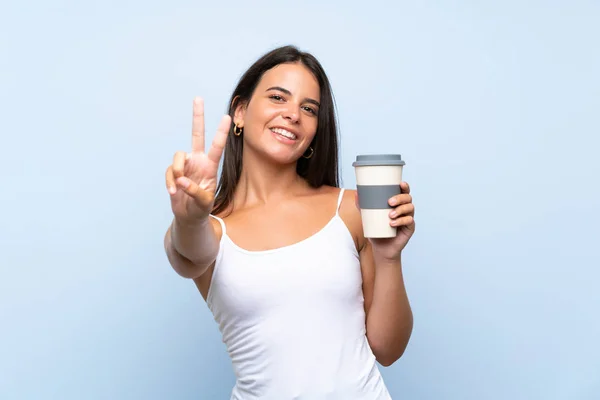 Mujer Joven Sosteniendo Café Para Llevar Sobre Fondo Azul Aislado — Foto de Stock