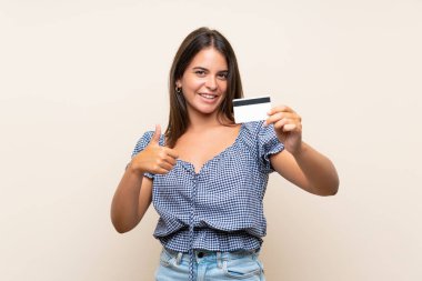 Bir kredi kartı tutan izole arka plan üzerinde genç kız