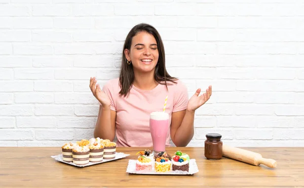 Junges Mädchen Mit Vielen Verschiedenen Mini Kuchen Lacht — Stockfoto