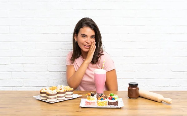 Junges Mädchen Mit Vielen Verschiedenen Mini Kuchen Flüstert Etwas — Stockfoto