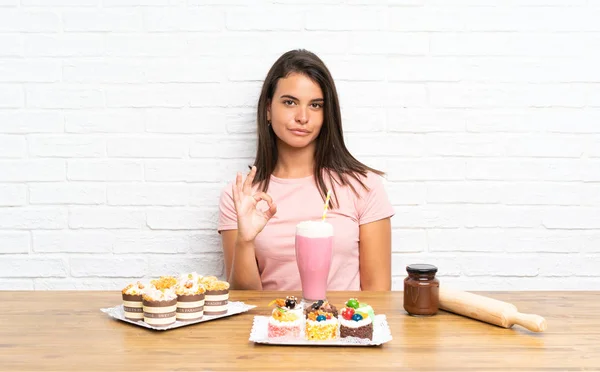 Junges Mädchen Mit Vielen Verschiedenen Mini Kuchen Die Ein Zeichen — Stockfoto