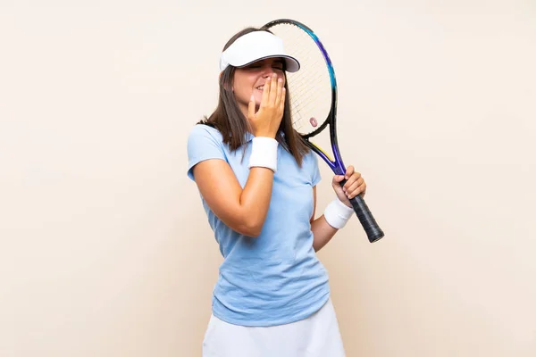 孤立した背景の上でテニスをしている若い女性はたくさん微笑む — ストック写真