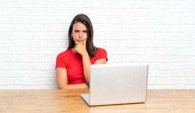 Bir masada gülerek pc ile genç kız