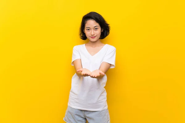 Asiática Joven Mujer Sobre Aislado Amarillo Pared Celebración Copyspace Imaginario —  Fotos de Stock