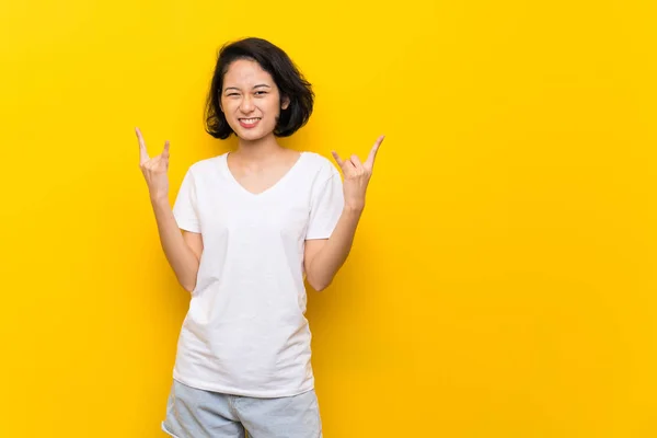 Asiática Joven Mujer Sobre Aislado Amarillo Pared Haciendo Rock Gesture —  Fotos de Stock