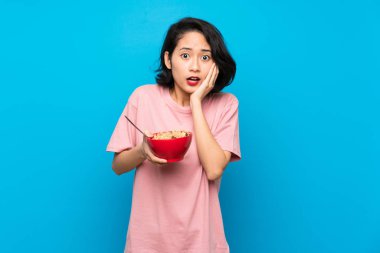 Asyagenç kadın sürpriz ve şok yüz ifadesi ile tahıl bir kase tutan