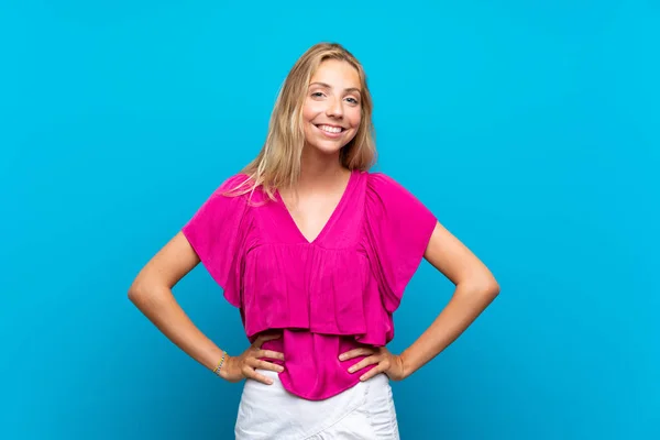 Blonde Junge Frau Vor Isoliertem Blauen Hintergrund Posiert Mit Armen — Stockfoto