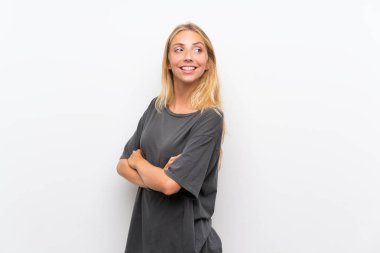 Kolları çapraz ve mutlu izole beyaz arka plan üzerinde Sarışın genç kadın