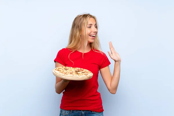 Mujer Rubia Joven Sosteniendo Una Pizza Sobre Una Pared Azul — Foto de Stock