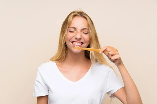 Счастливая молодая блондинка чистит зубы — стоковое фото
