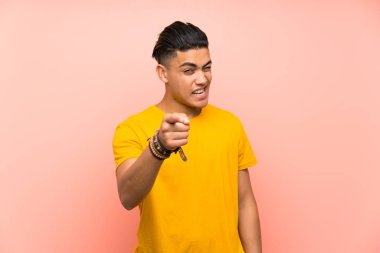 Izole pembe duvar noktaları parmak üzerinde sarı gömlekli genç adam size parmak