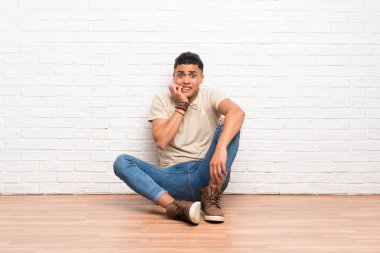 Genç adam sinirli ve korkmuş katta oturan