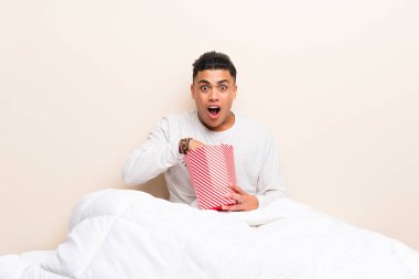 Patlamış mısırile yatakta genç adam