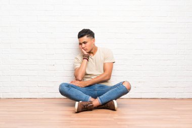 Genç adam mutsuz ve sinirli katta oturan