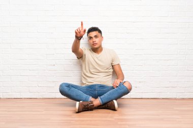 Şeffaf ekrana dokunarak yerde oturan genç adam