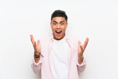 Sürpriz yüz ifadesi ile izole beyaz duvar üzerinde genç adam