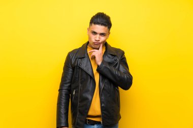 Izole sarı arka plan üzerinde genç adam ön bakıyor