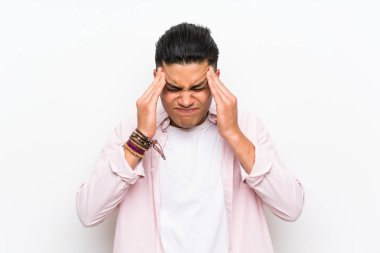 Izole beyaz duvar üzerinde genç adam mutsuz ve bir şey ile sinirli. Negatif yüz ifadesi