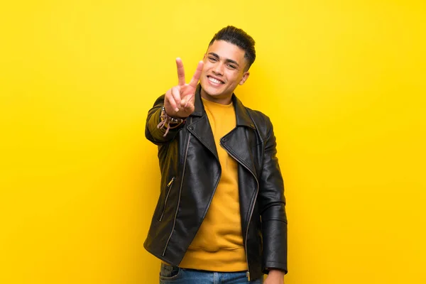 Mladý Muž Přes Izolované Žluté Pozadí Usmívá Zobrazuje Vítězné Znamení — Stock fotografie