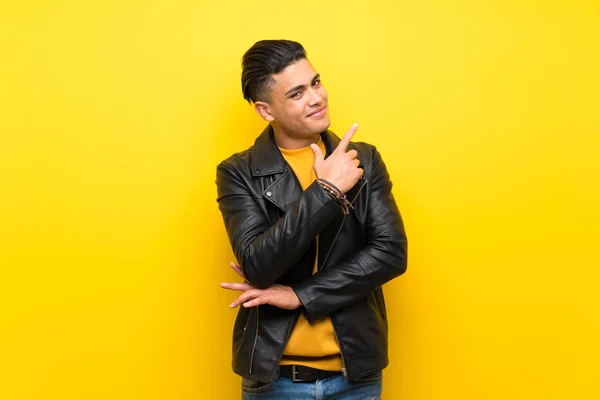 Young man over isolated yellow background smiling