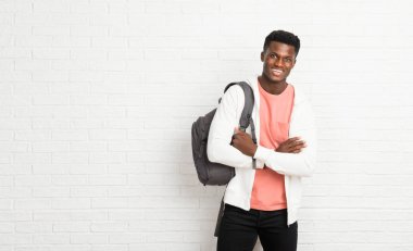Genç afro Amerikalı adam öğrenci gülümseyerek kollarını çapraz tutmak