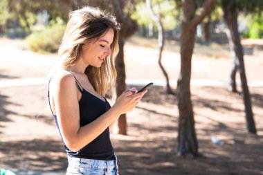 Cep telefonu kullanarak açık havada genç kız