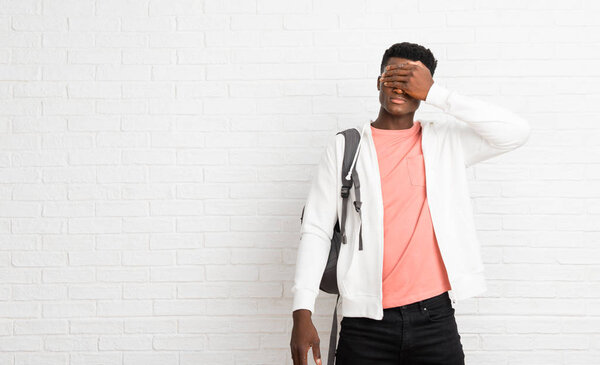 Young afro american man student covering eyes by hands. Do not want to see something