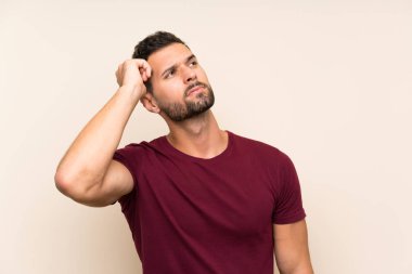 Izole arka plan üzerinde yakışıklı adam şüpheleri olan ve yüz ifadesi karıştırmayın
