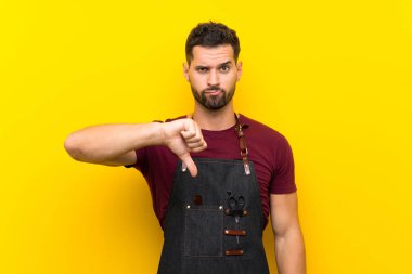 Bir önlük içinde Berber adam başparmak aşağı işareti gösteren