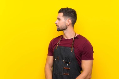 Önlüklü berber yan tarafa bakıyor.