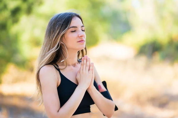 Young sport woman in zen position at outdoors