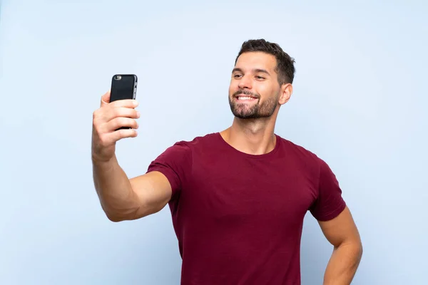 Hombre Guapo Sobre Fondo Azul Aislado Haciendo Una Selfie —  Fotos de Stock