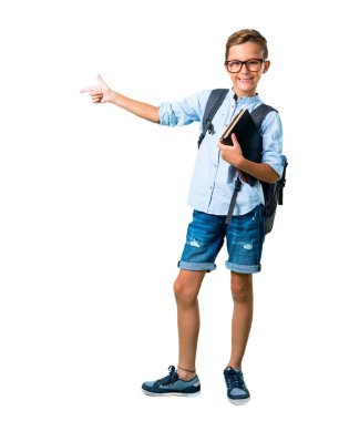 Sırt çantası ve gözlük yan parmak işaret ve izole beyaz arka plan üzerinde bir ürün sunan Öğrenci çocuk tam vücut