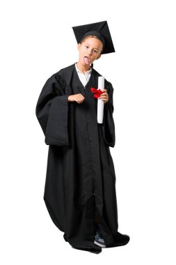 Izole beyaz arka plan üzerinde komik bir görünüme sahip kamera dilini gösteren mezun Küçük çocuk tam vücut