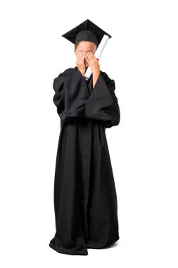 Izole beyaz arka plan üzerinde elleri ile gözleri kaplayan mezun Küçük çocuk tam vücut