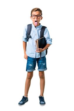 Izole beyaz arka plan üzerinde komik bir görünüme sahip kamera da dil gösteren sırt çantası ve gözlük ile Öğrenci çocuk tam vücut